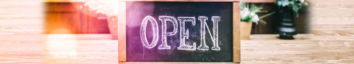 small chalkboard on table with 'Open' written upon it