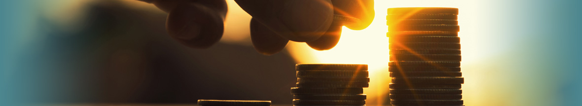 cloes up of a hand stacking coins up in columns