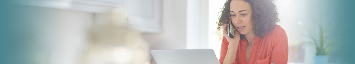 woman on the phone while looking at her computer