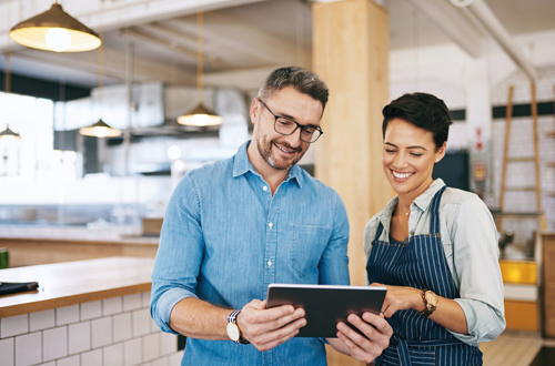 man and woman looking at tablet