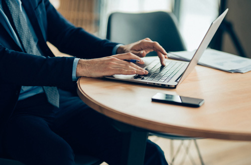 man typing on a laptop