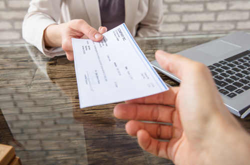 person handing a check to another person