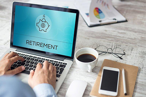 man typing on a laptop that says retirement