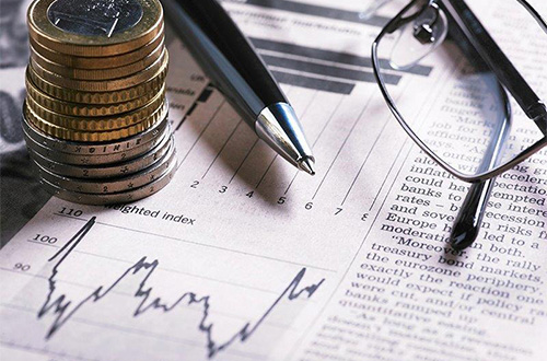 a stack of coins, a pen, and reading glasses